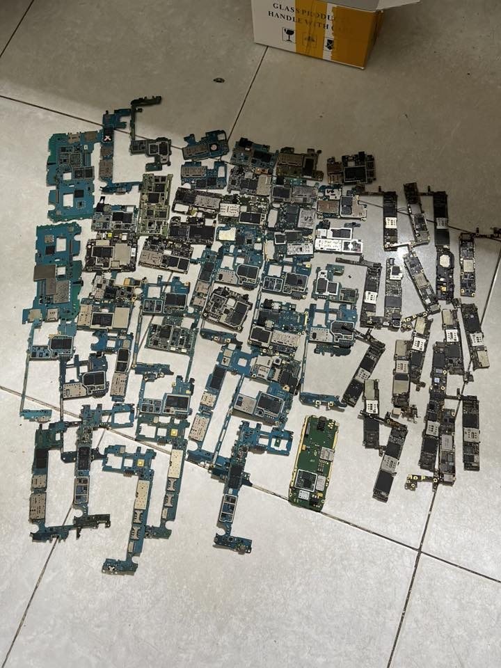 Stripped smartphone motherboards scattered on a tiled floor